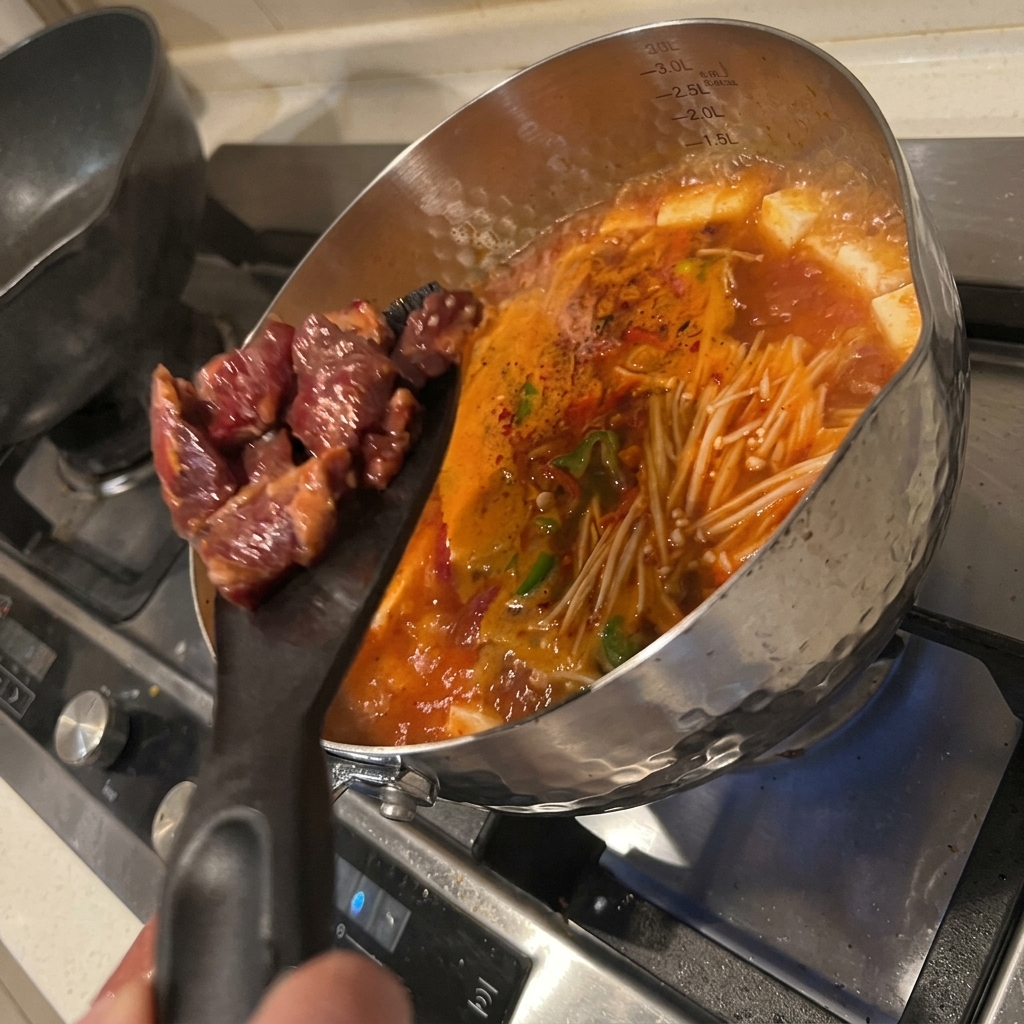 Le bœuf mariné ajouté dans le bouillon bouillonnant.