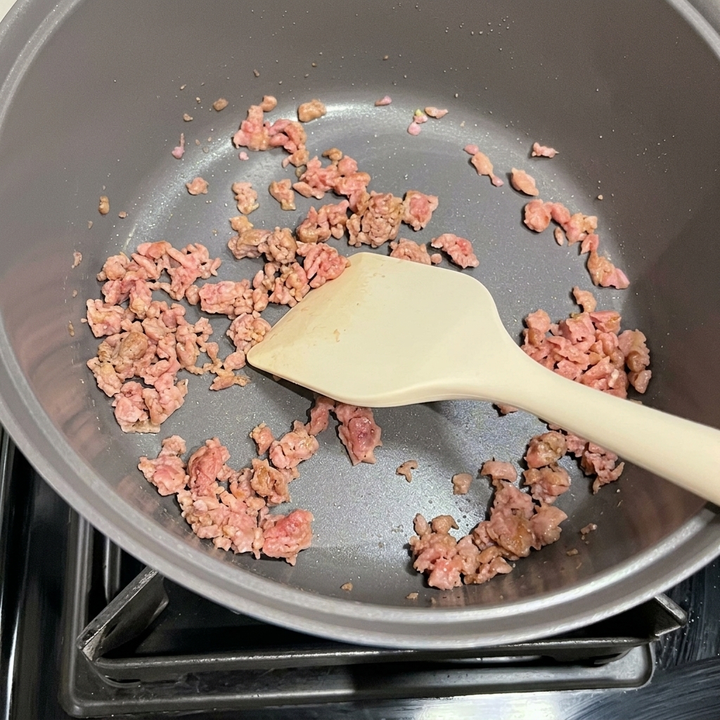 Kimchi et Spam doré sautés ensemble dans une marmite.