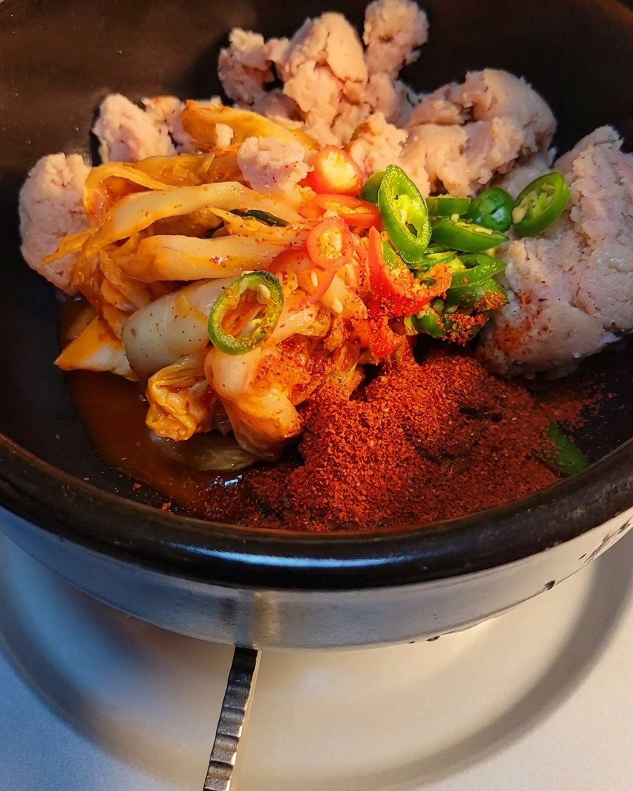 Gros plan sur le sucre et la poudre dassaisonnement au bœuf saupoudrés sur le kimchi et le jambon.