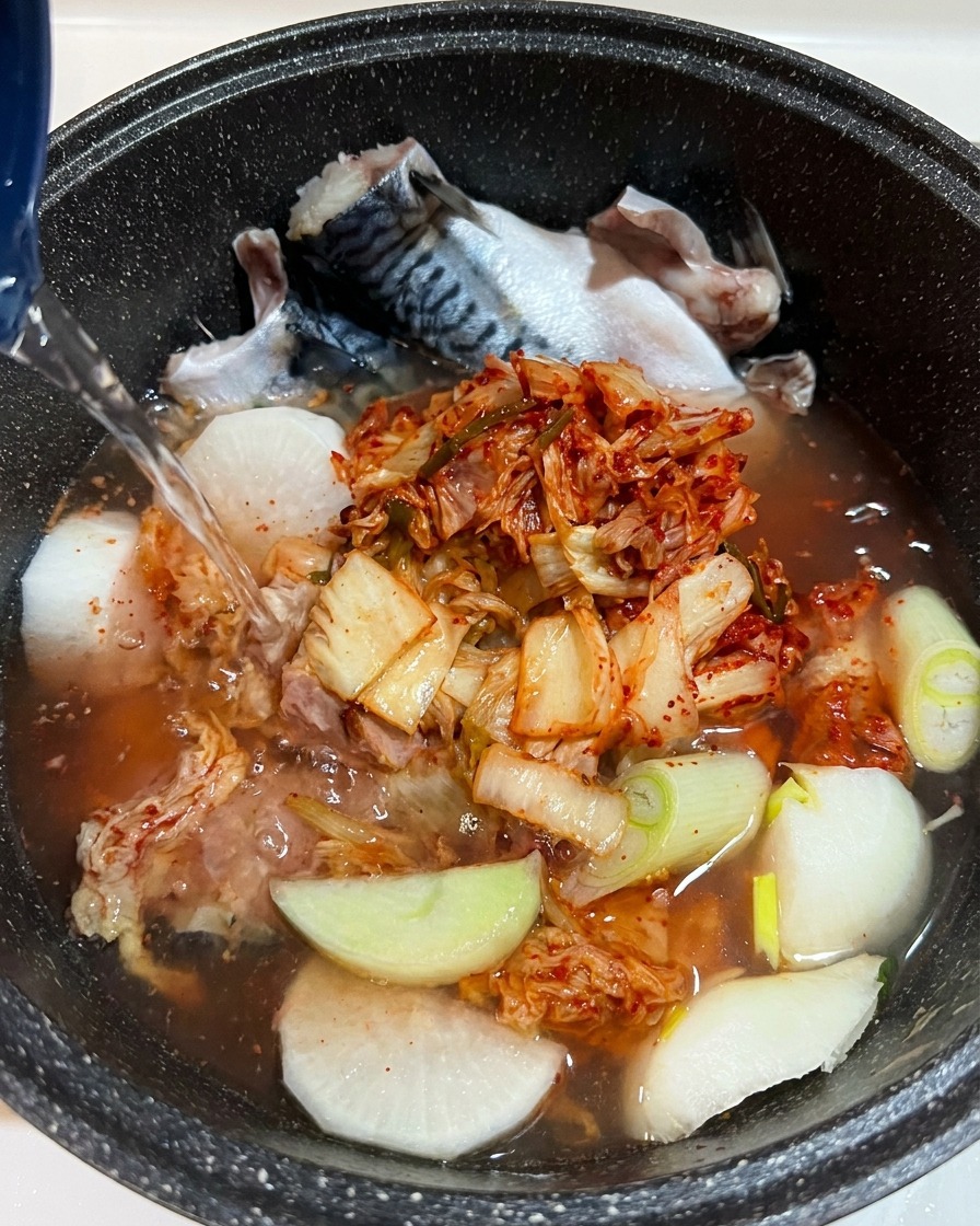 Gros plan sur lassaisonnement liquide ajouté dans la casserole, avec les ingrédients clairement visibles sous leau.
