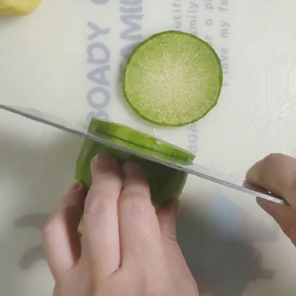 Radis frais coupé en rondelles épaisses sur une planche à découper.