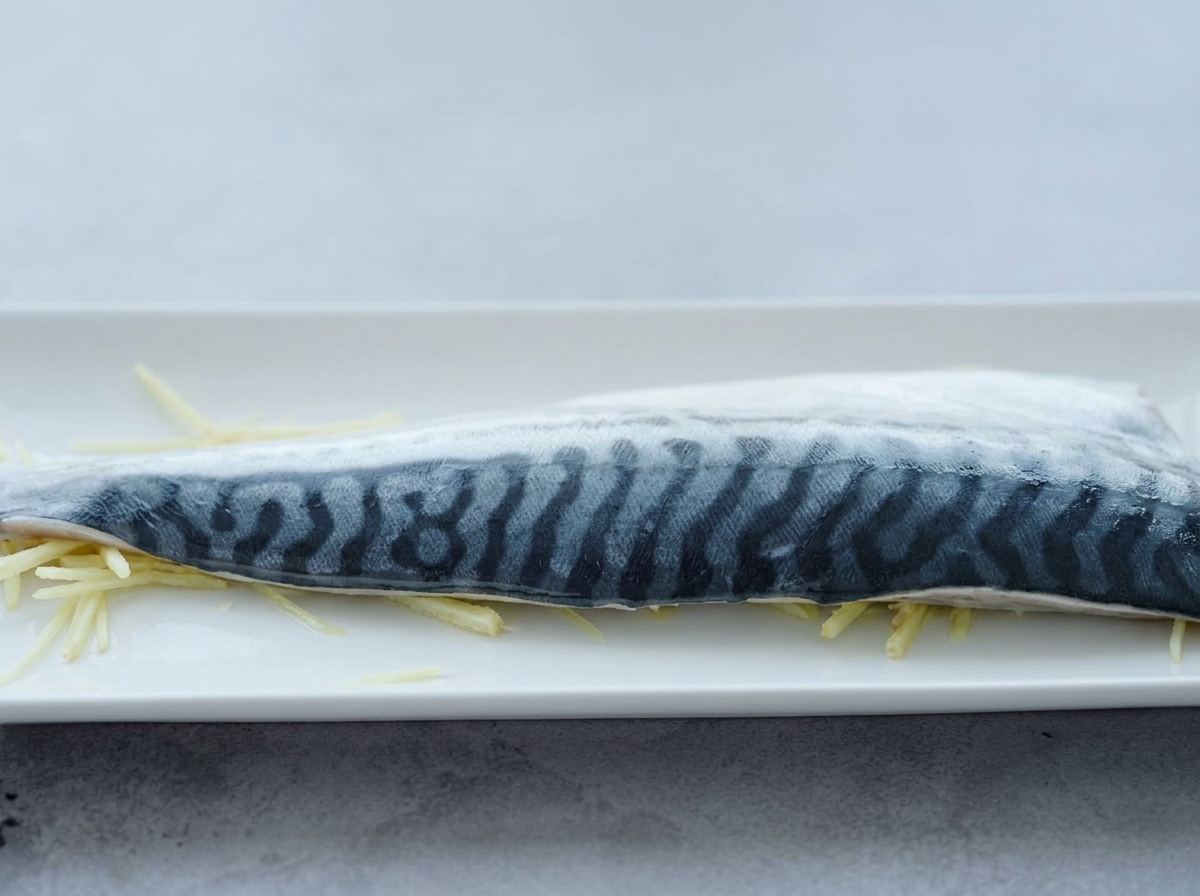 Filet de maquereau sur un lit de gingembre, arrosé de saké.