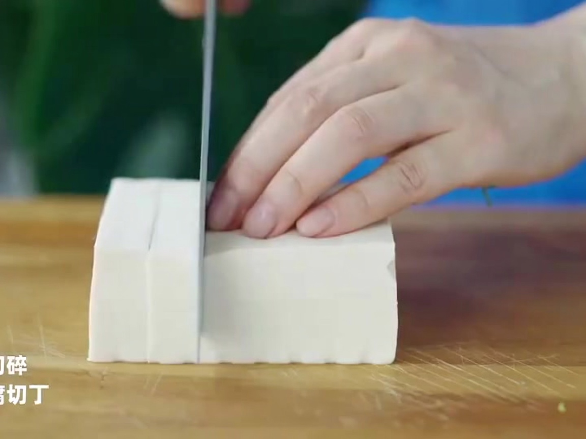 Cubes de tofu découpés sur une planche à découper.