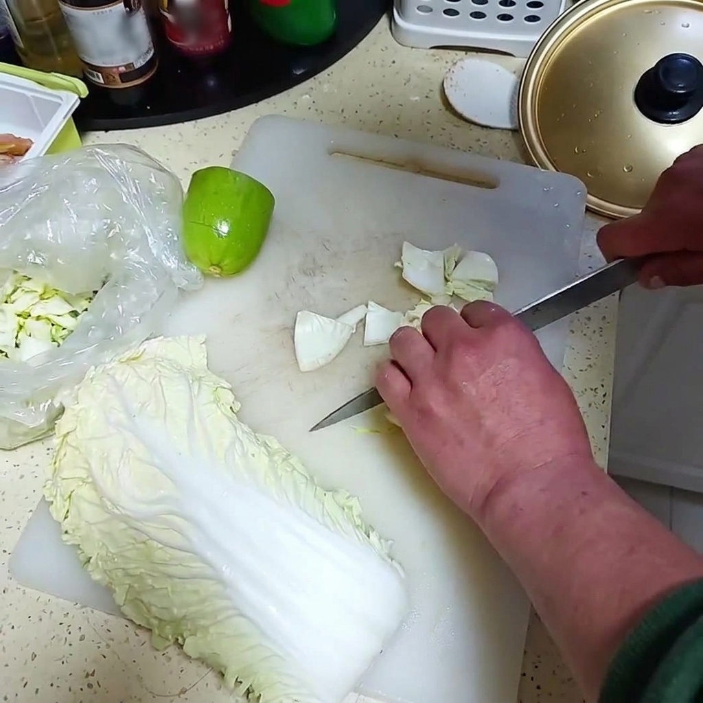 Oignon frais et un petit melon vert coupés en morceaux sur une planche à découper blanche.