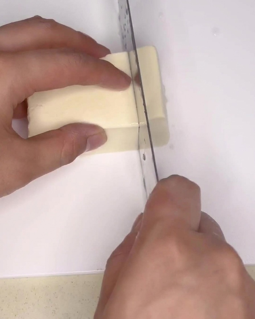 Bloc de tofu ferme coupé en petits rectangles réguliers sur une planche.