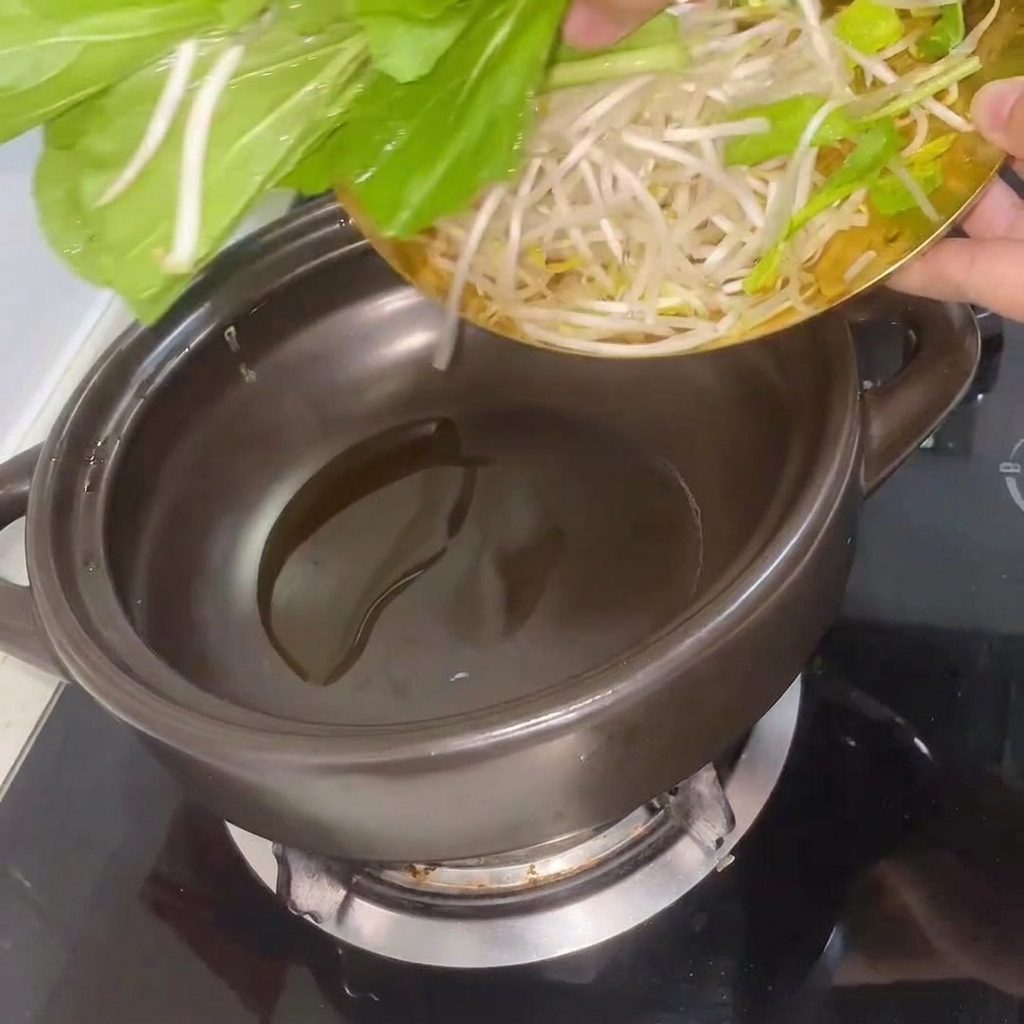 Bok choy frais et pousses de soja sautés dans la marmite chauffée.