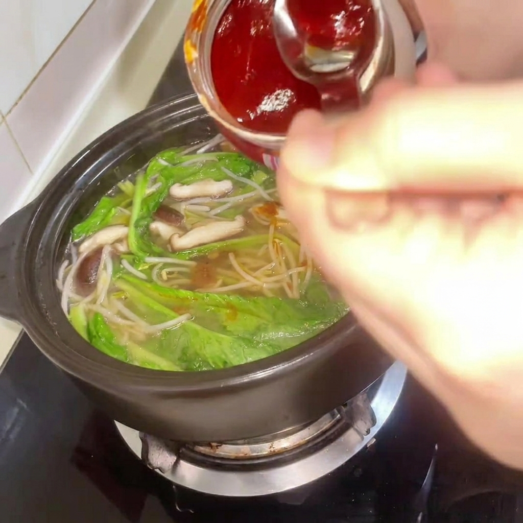 Pâte de piment coréenne ajoutée au ragoût pendant que le bouillon est mélangé.