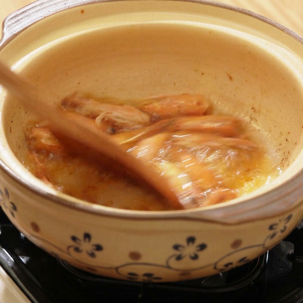 Eau chaude versée dans le faitout sur les têtes de crevettes.
