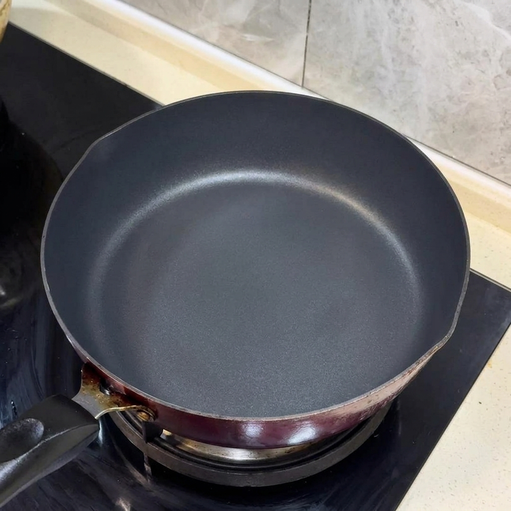 Oignons verts hachés et lanières de gingembre grésillant dans lhuile chaude dans une poêle noire.