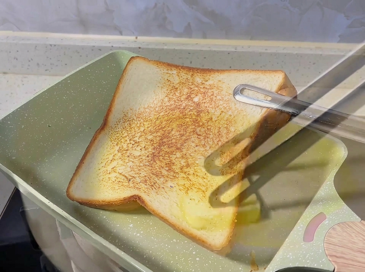 Oignons rouges en dés grésillant dans du beurre fondu dans une poêle.