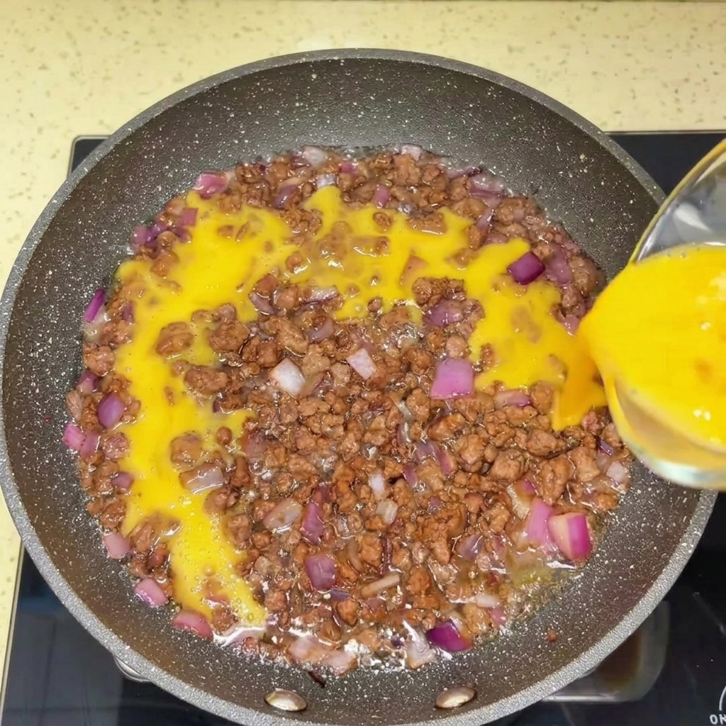 Bœuf haché en cours de préparation dans une poêle chaude avec une spatule.