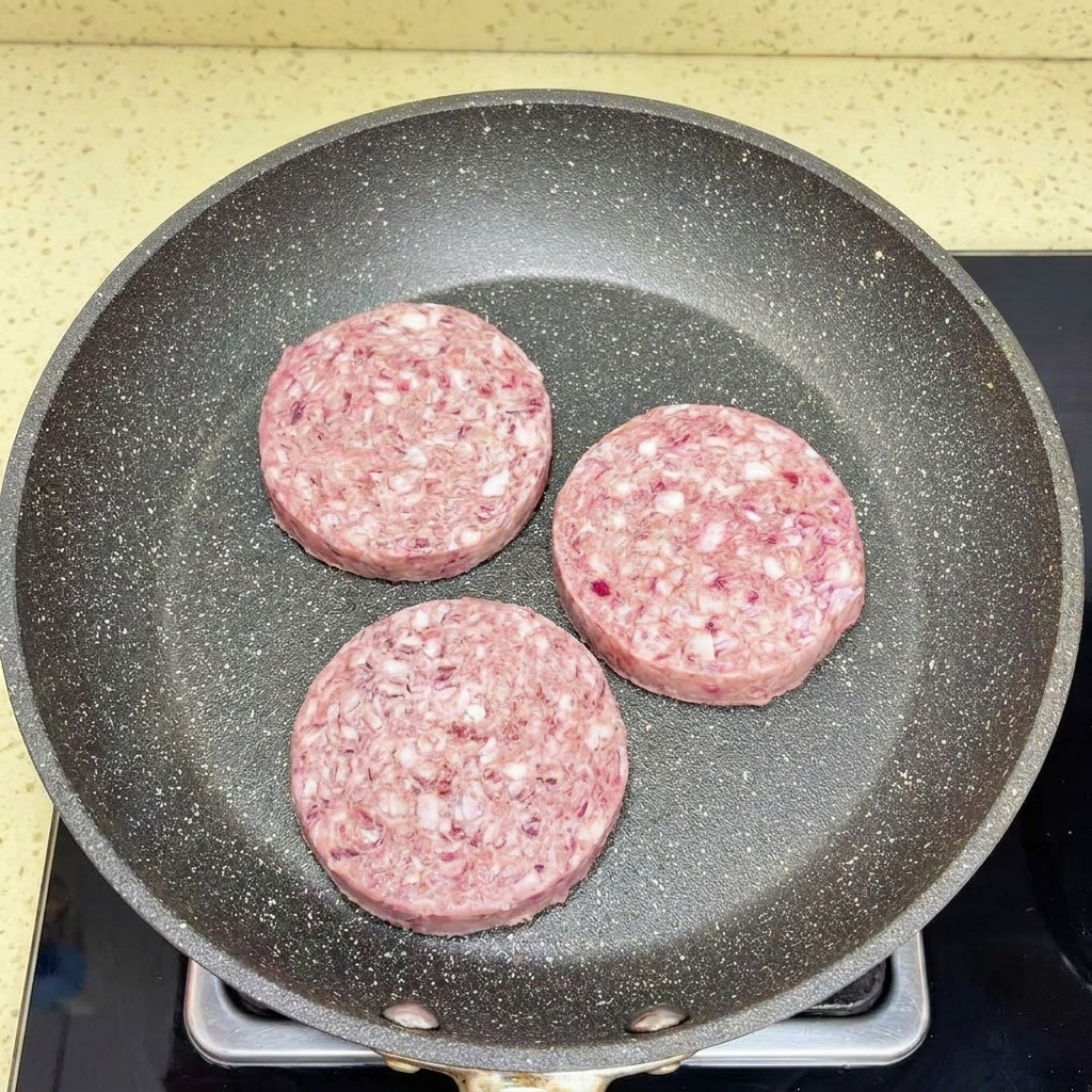Bœuf haché émietté dans une poêle chaude à laide dune spatule blanche.