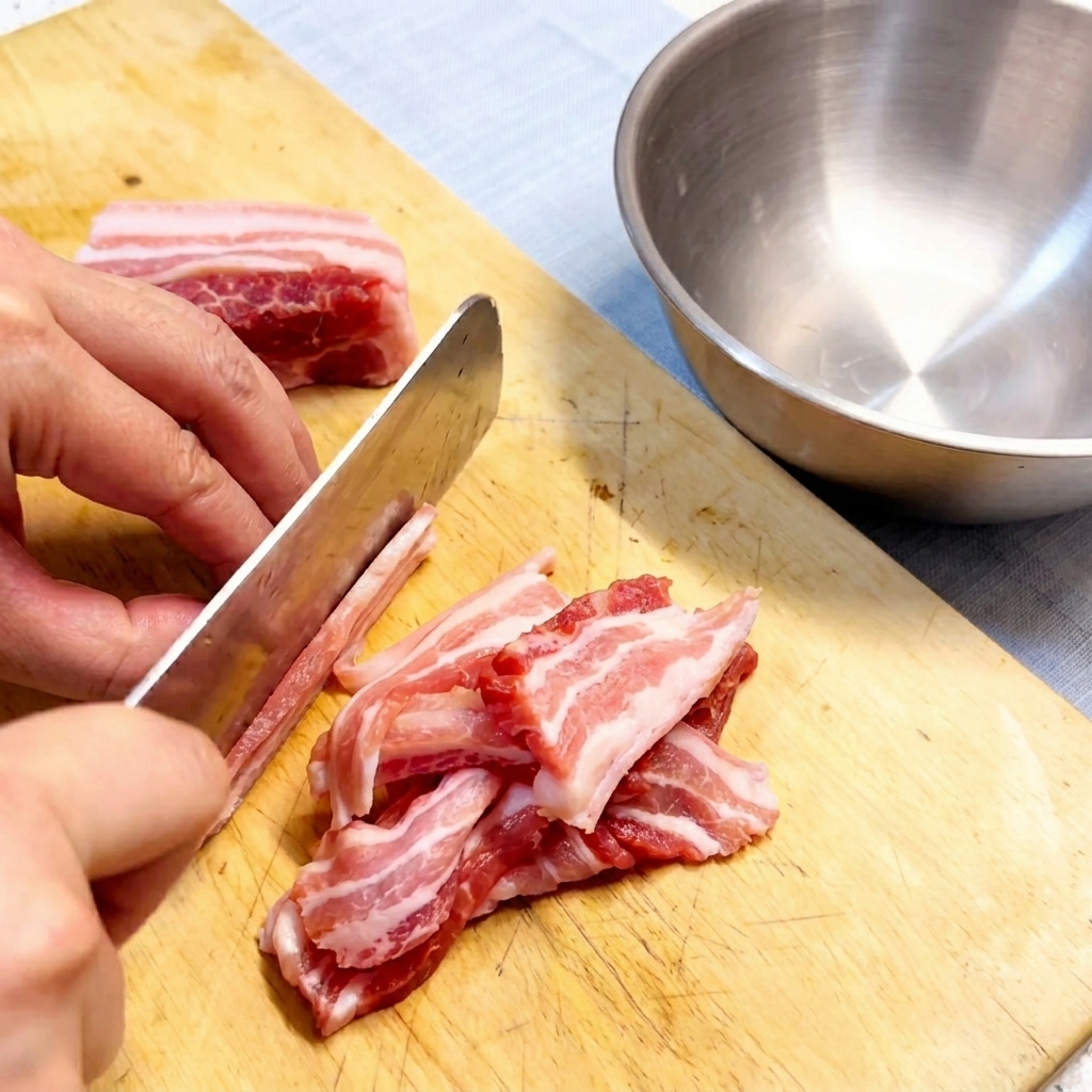Tranches de poitrine de porc crue disposées proprement sur une planche à découper en bois.