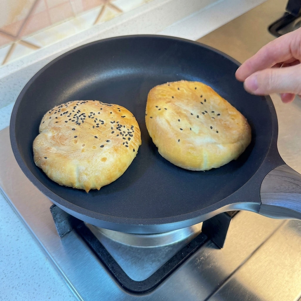 Pains dans une poêle couverts pour la cuisson vapeur.