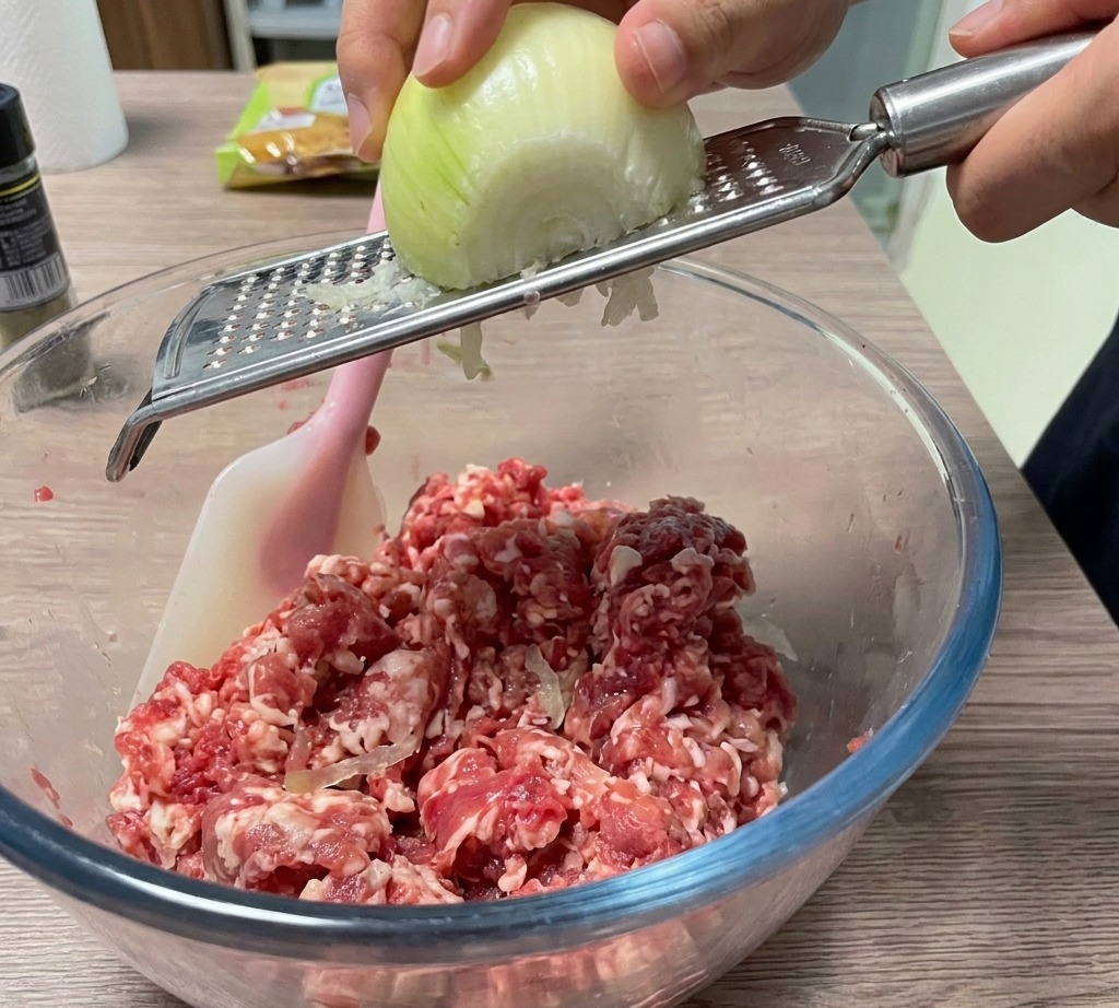 Oignon râpé au-dessus du saladier de viande.