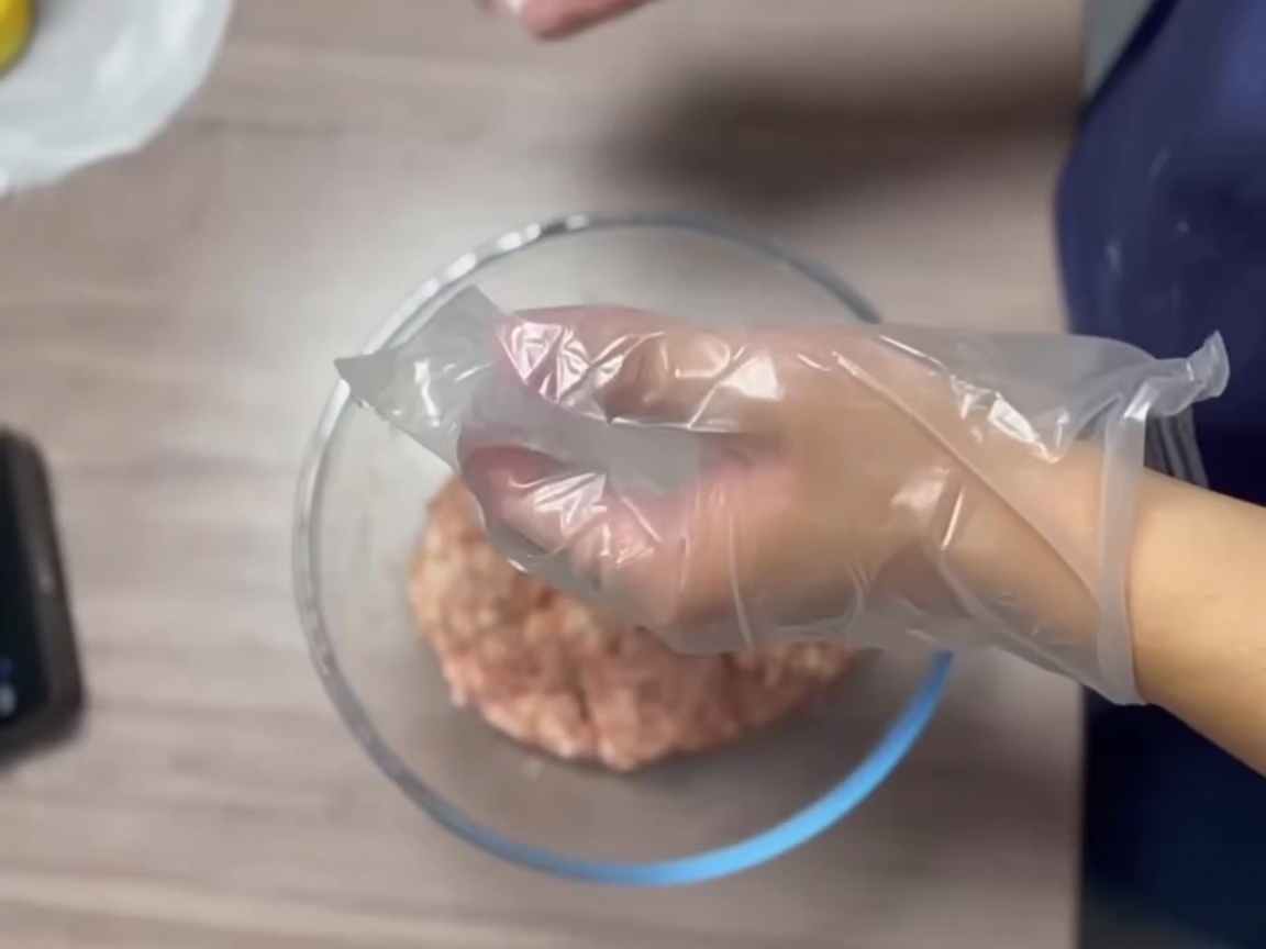 Mains gantées formant une boule de viande lisse.