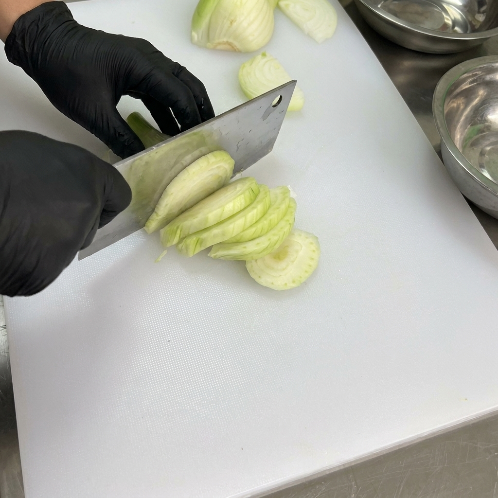 Poivrons frais nettoyés et épépinés sur une planche à découper blanche.