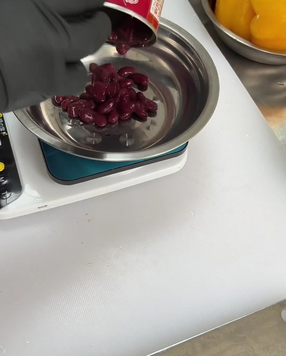 Haricots rouges ajoutés au bol avec les épices et les piments.