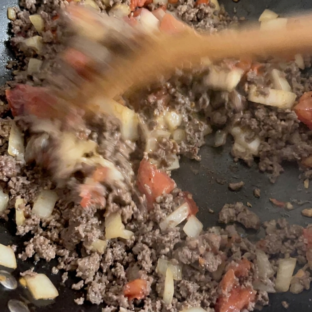 Bœuf haché doré et légumes sautés mélangés ensemble dans un wok.