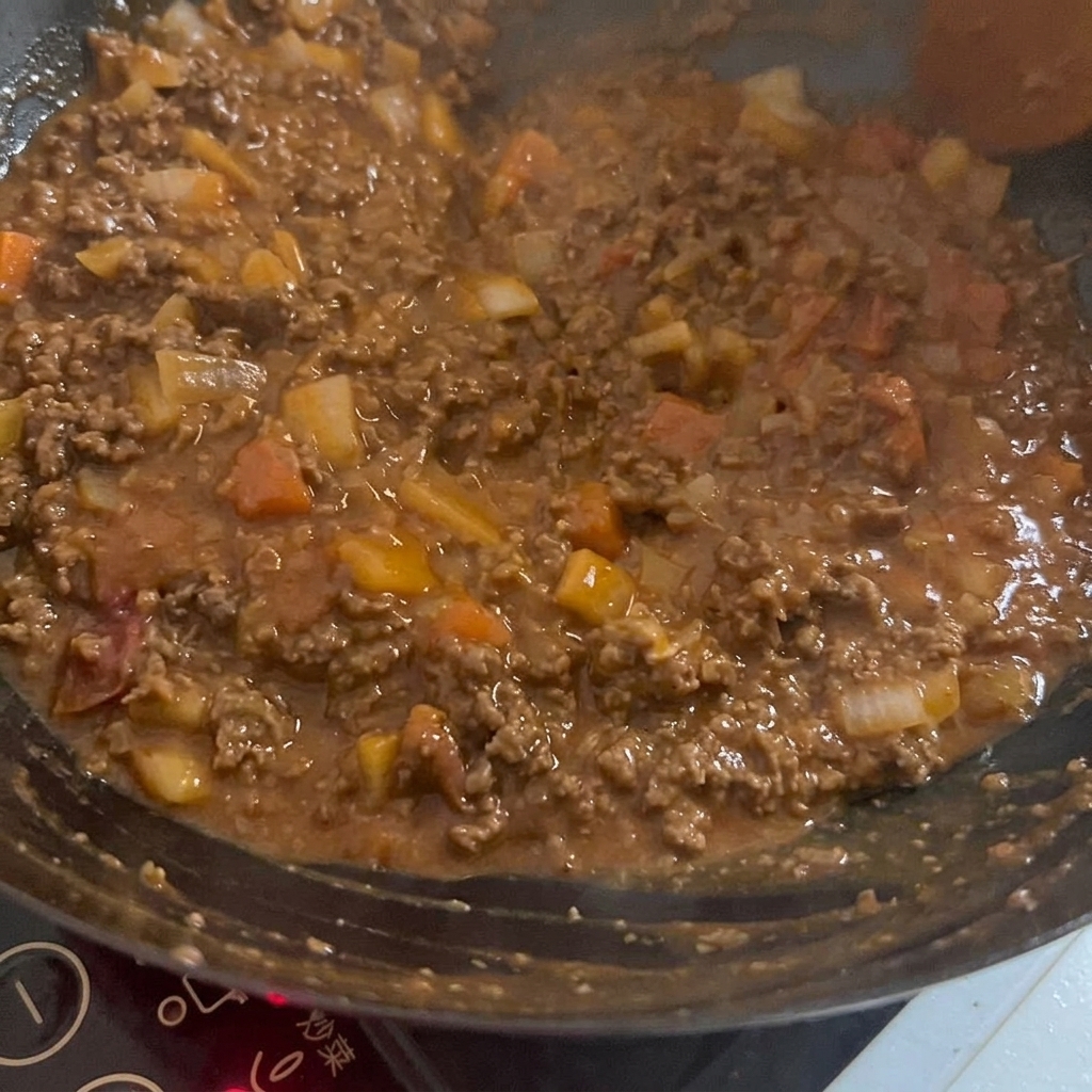 Une sauce riche et sombre incorporée au mélange de bœuf et légumes dans un wok chaud.