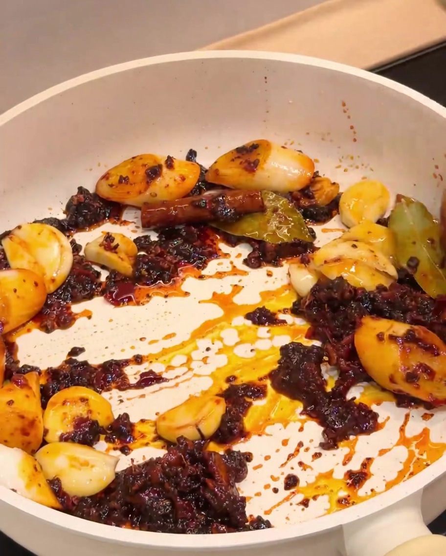 Les écrevisses frites mélangées à la base dépices aromatiques dans une poêle.