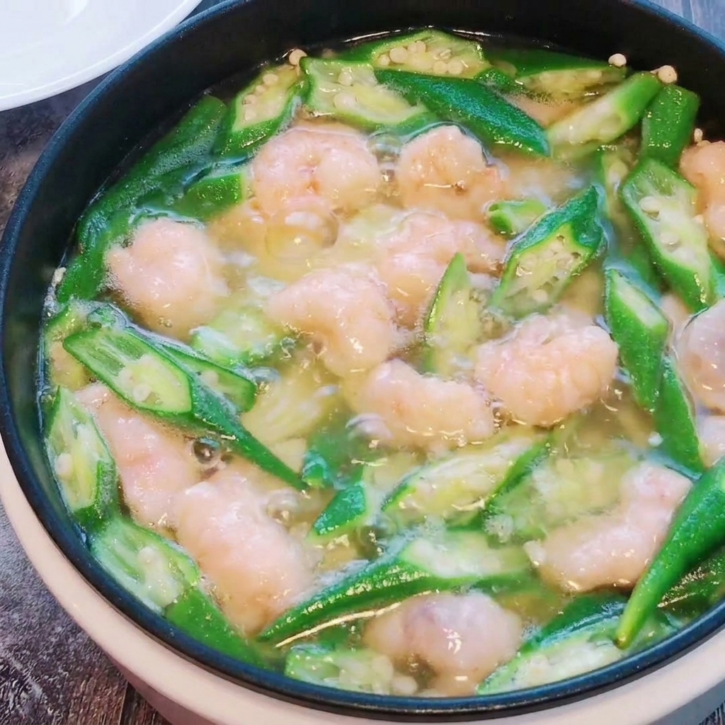 Les boulettes de pâte de crevettes sont délicatement mélangées dans la soupe de gombo et tofu pendant la cuisson.