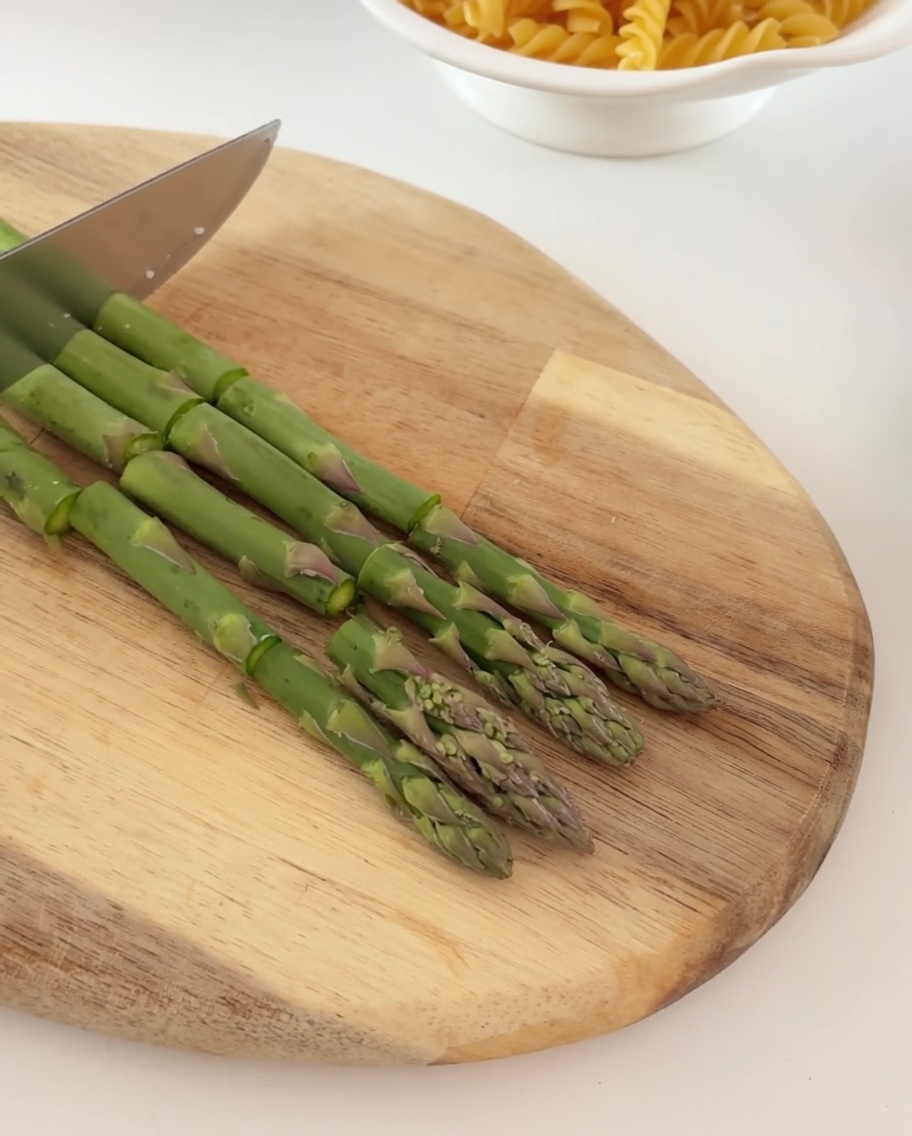 Tranches de bacon cru coupées en petits morceaux sur une planche en bois.