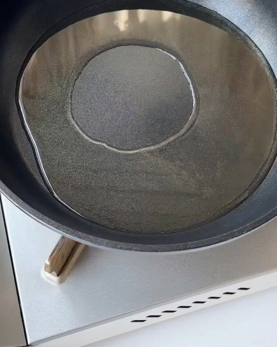 Oignon rouge émincé sauté dans une poêle chaude avec un peu dhuile de cuisson.