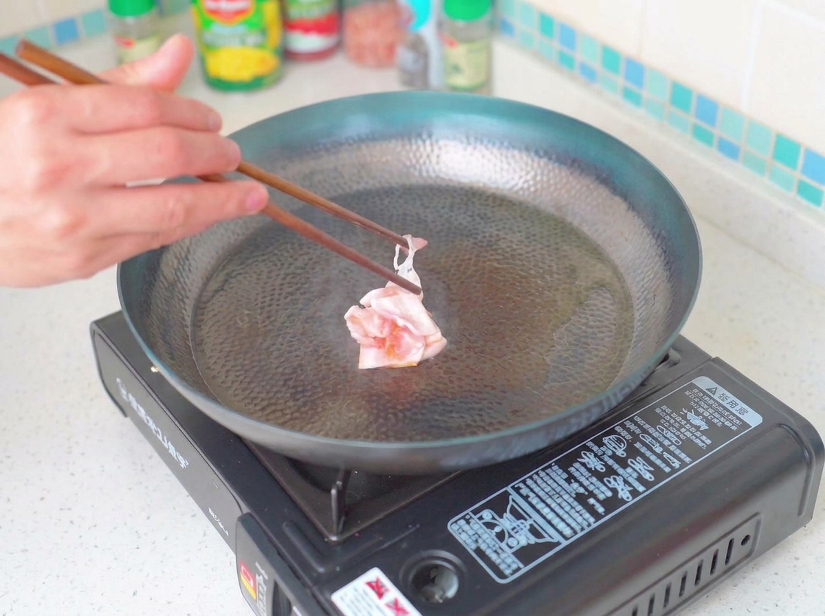 Morceaux de bacon dorés et croustillants dans une poêle.