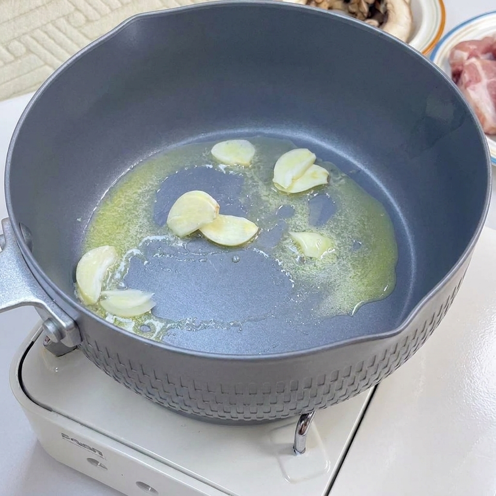 Des tranches de bacon et des champignons émincés en train de dorer dans une poêle.