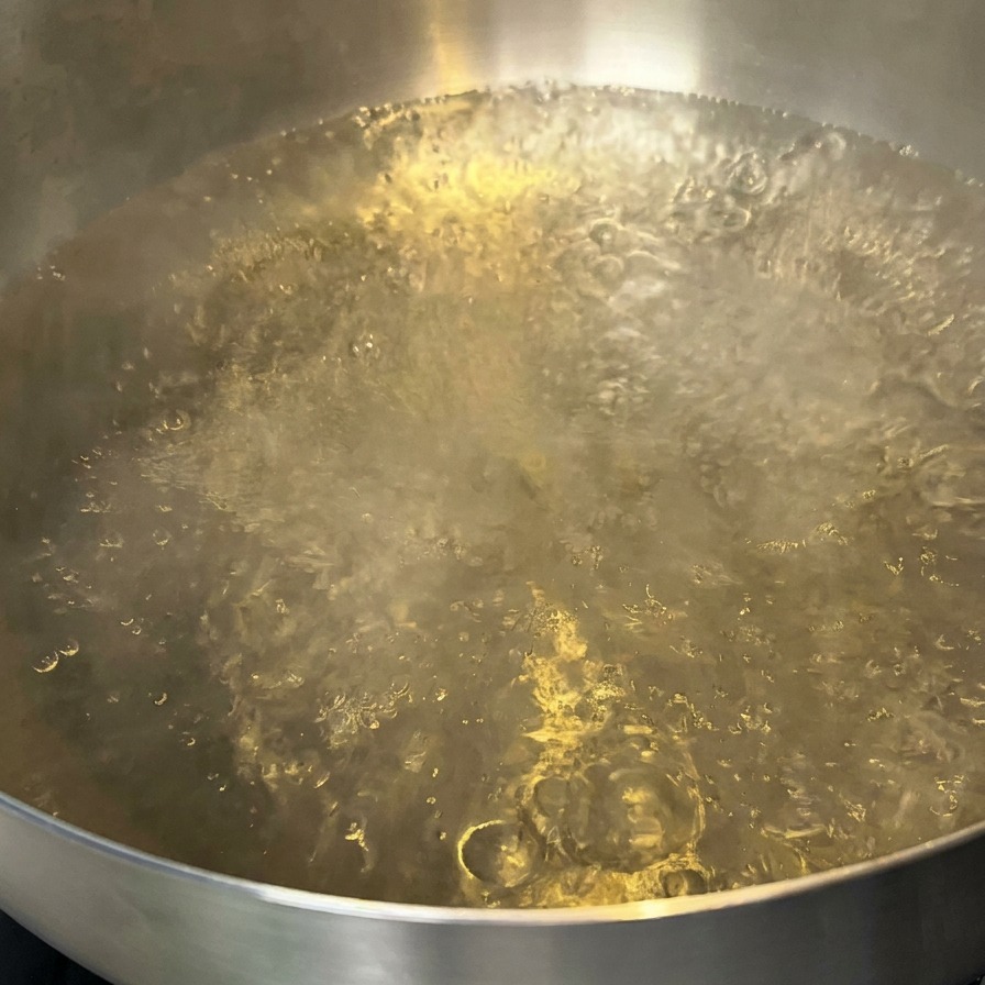 Une casserole deau bouillante avec un filet dhuile à la surface.