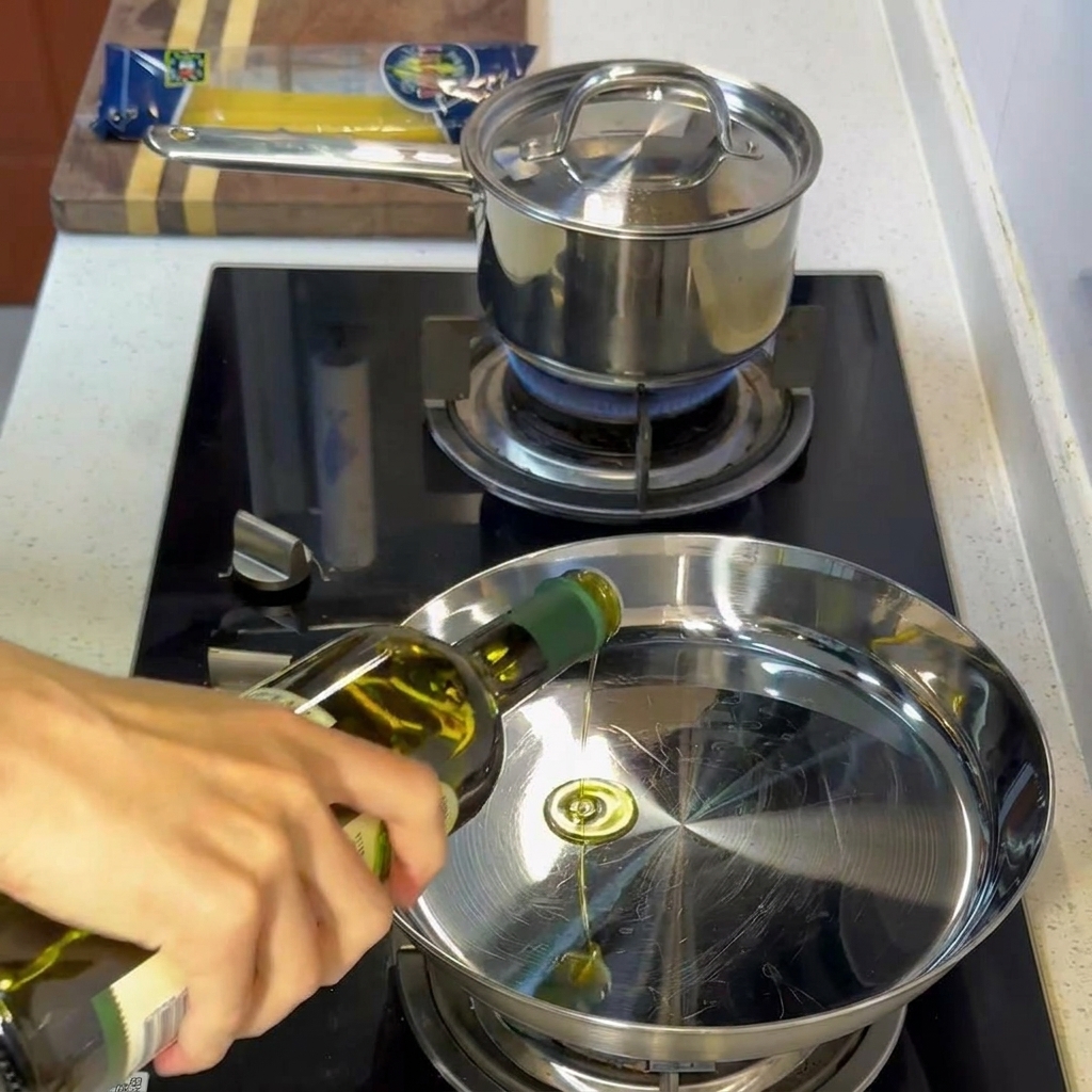 Huile dolive frémissante dans une poêle en inox chauffée.