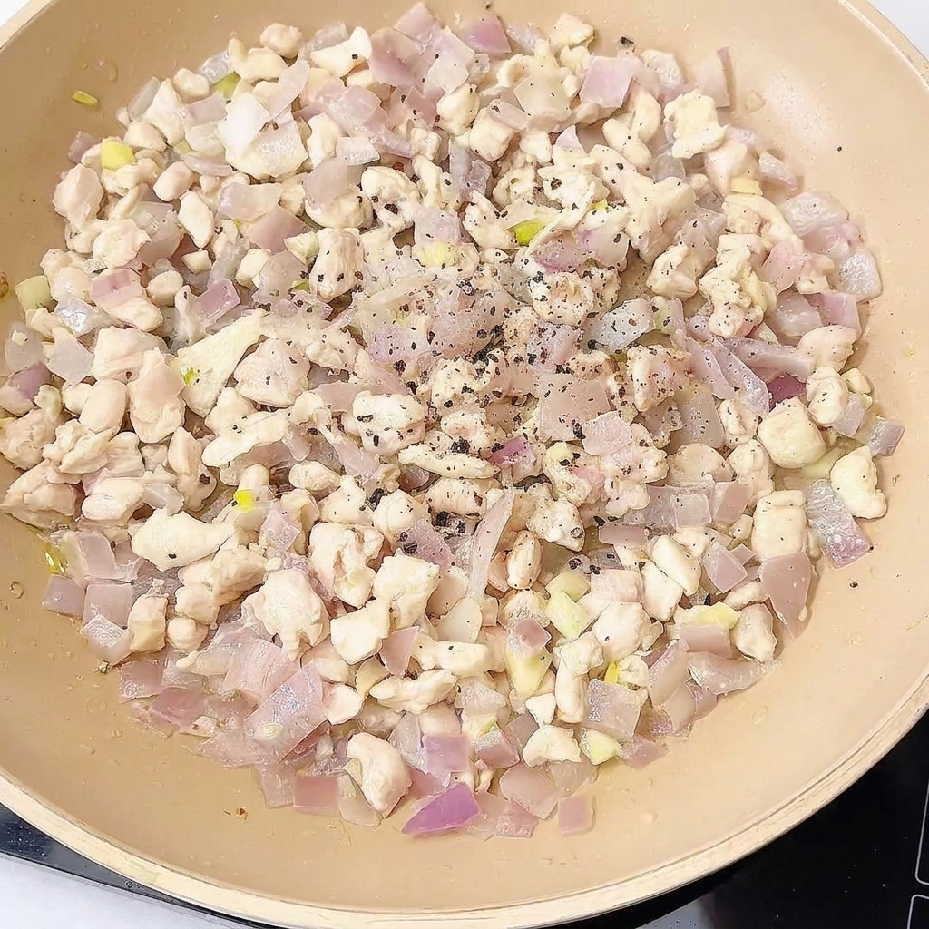 Mélange de poulet dans la poêle assaisonné avec épices et sauces.