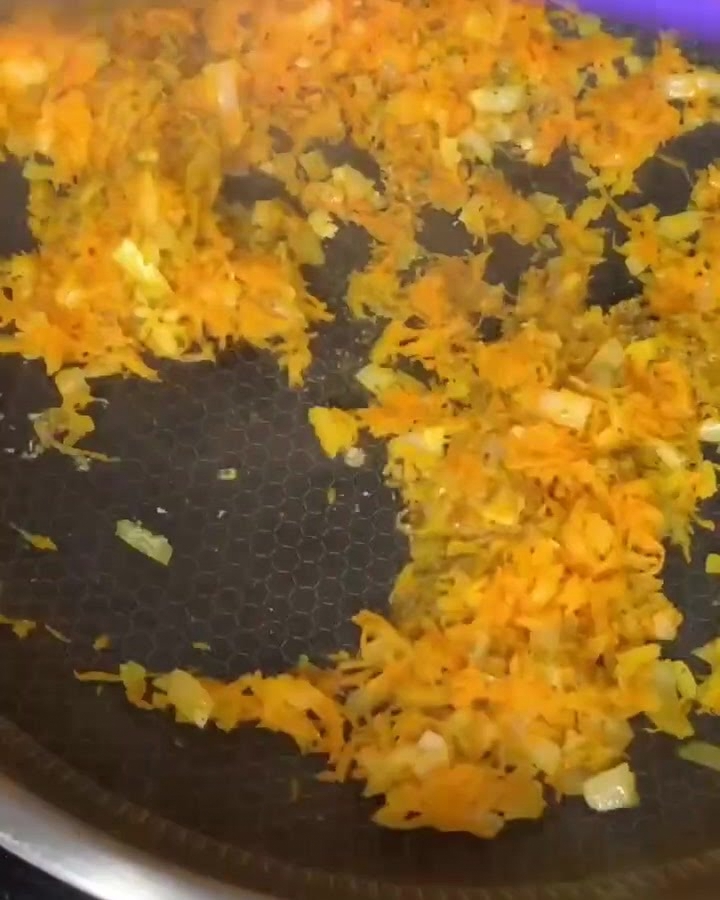 Bœuf haché mélangé aux carottes et oignons dans une poêle antiadhésive.