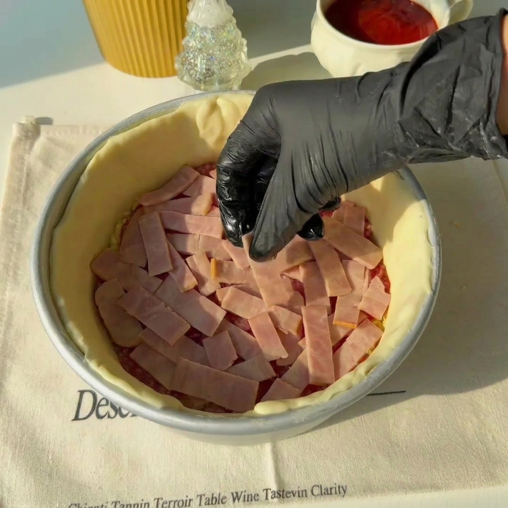 Tranches de jambon disposées sur la couche de salami à lintérieur du moule de cuisson.