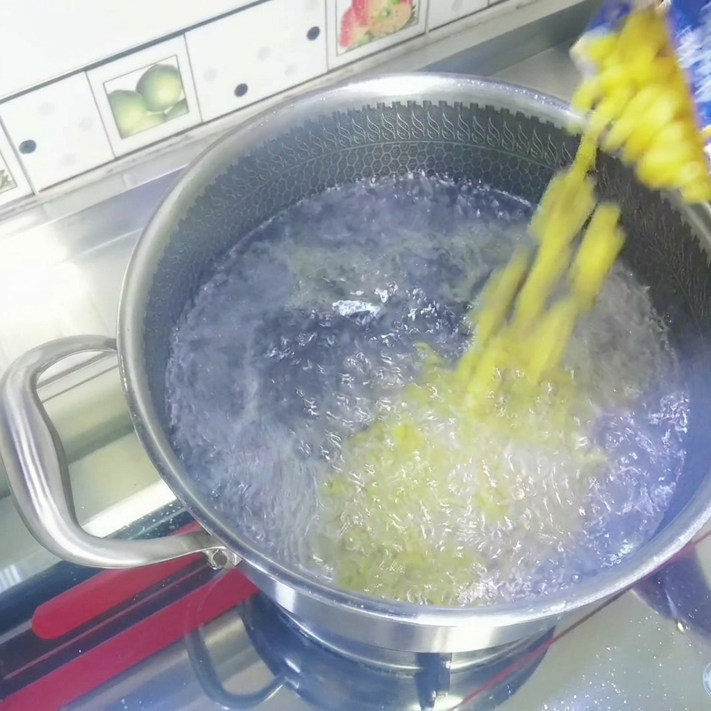 Macaronis secs versés depuis un sachet dans une casserole deau bouillante.