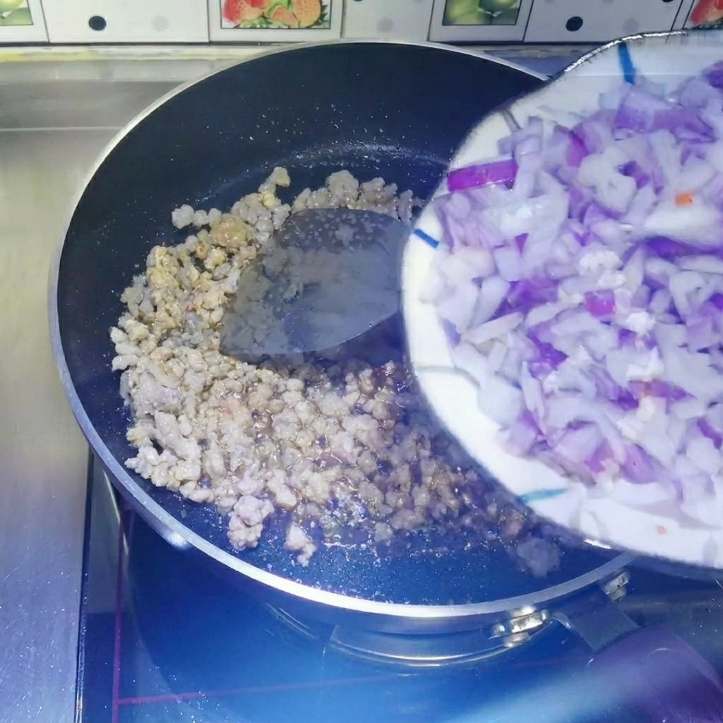 Dés doignon rouge ajoutés dans la poêle avec la viande cuite.