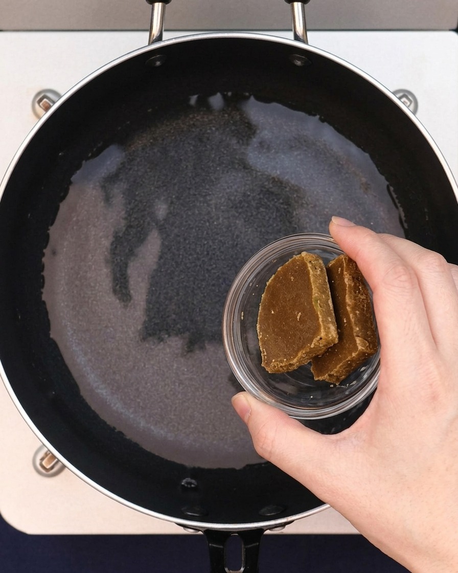 Deux blocs de roux de curry ajoutés à leau dans la poêle.