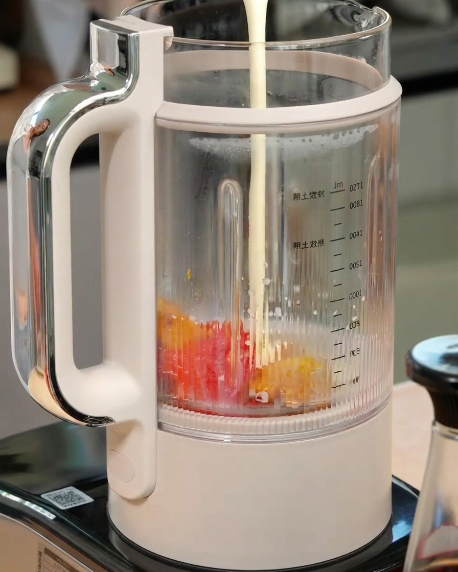 Lait et crème liquide versés dans un blender contenant du potiron et du poivron rôtis.
