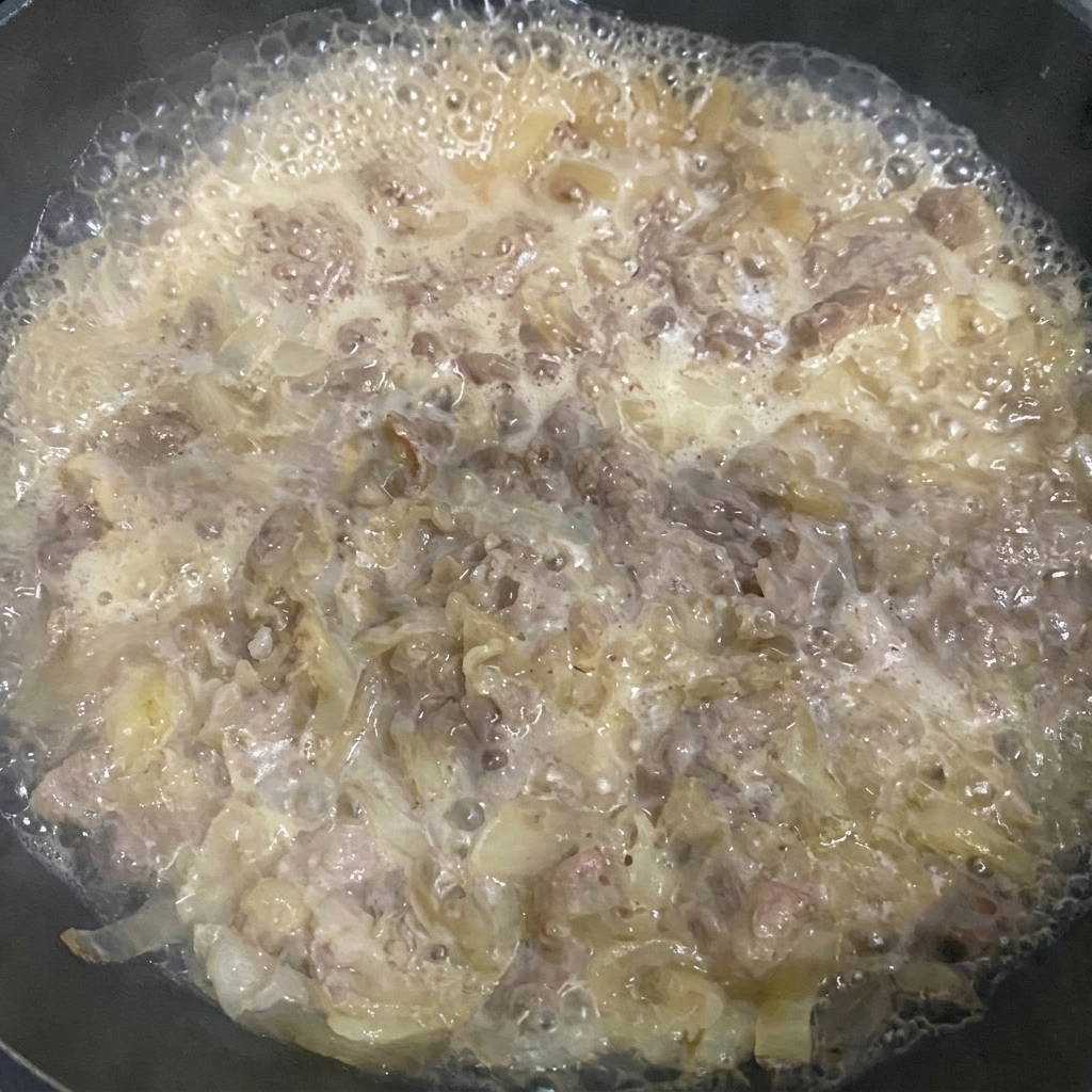 Retrait de lécume à la surface du bœuf mijoté à laide dune spatule.