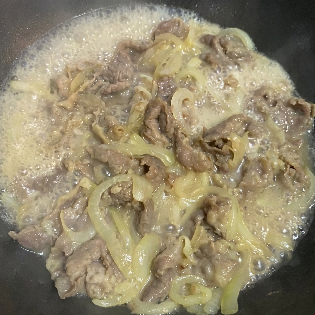 Assaisonnement du mélange bœuf et oignons avec la sauce soja, le sucre et le sel.