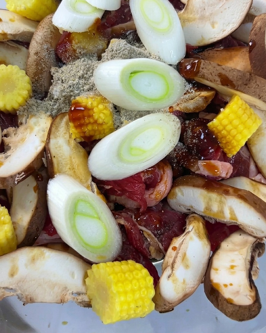Tranches doignons verts frais reposant sur le mélange de bœuf et de légumes assaisonnés.