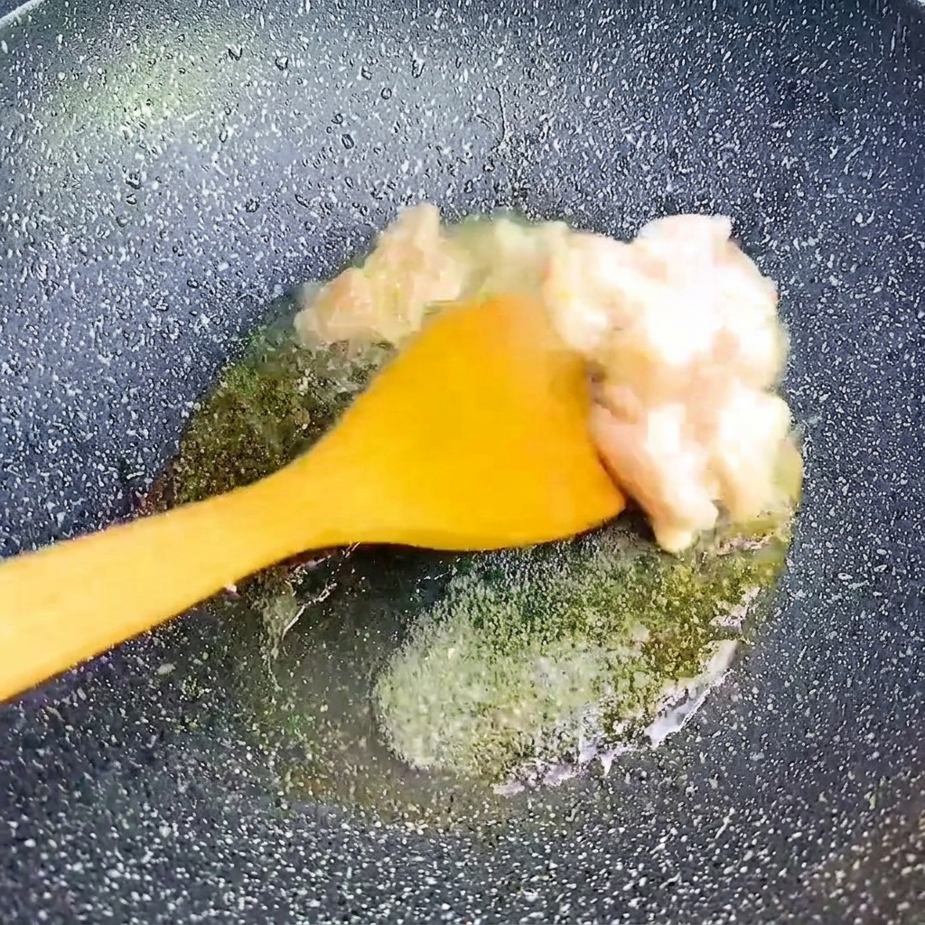 Morceaux de poitrine de porc sautés à la spatule dans une poêle chaude.