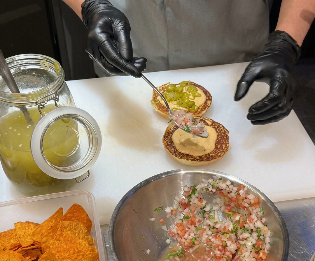 Moitiés de pain à burger beurrées grillant jusquà devenir dorées sur une plaque de cuisson.