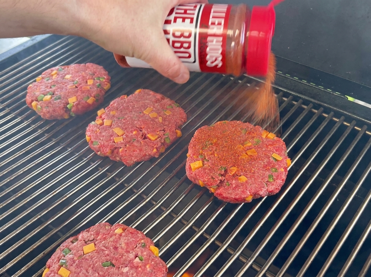 Steaks de bœuf assaisonnés au rub barbecue sur la grille du barbecue.