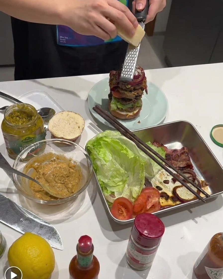 Parmesan frais râpé sur le burger assemblé.