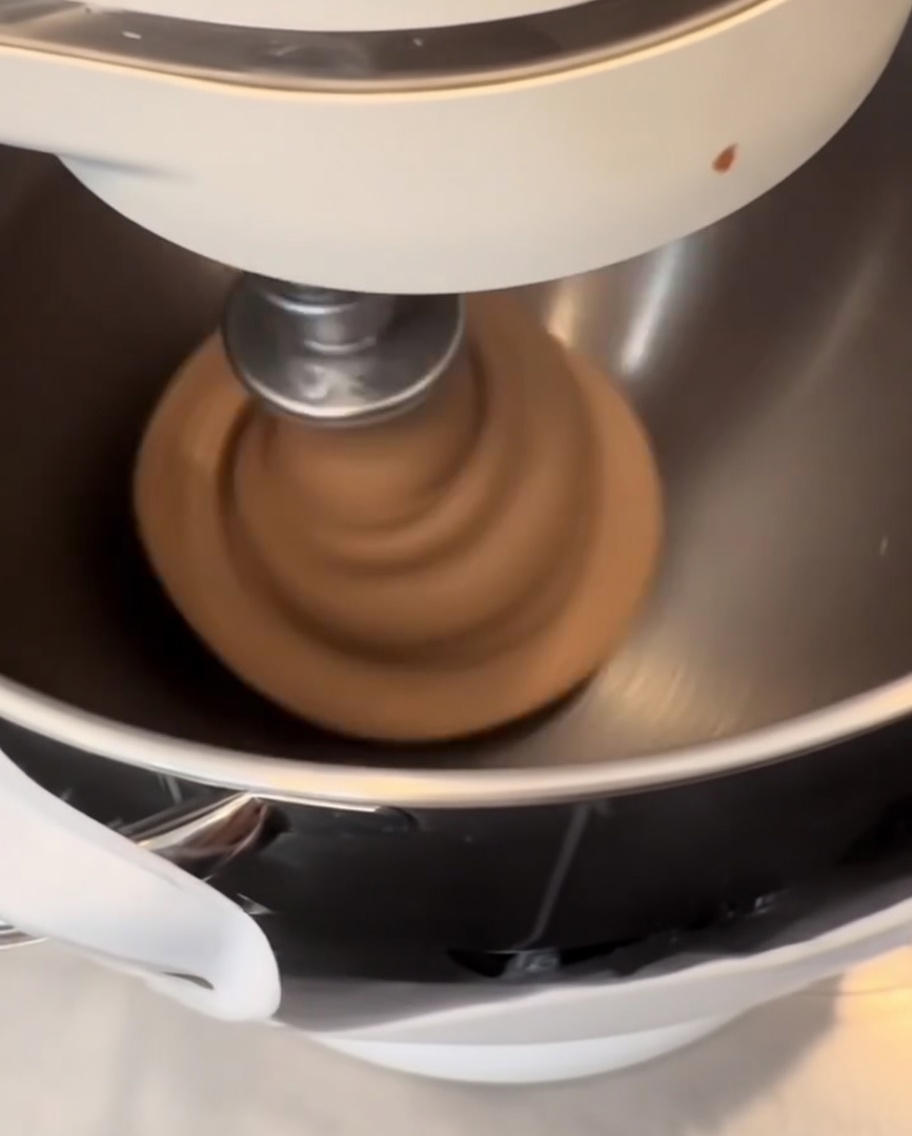 Pâte infusée au cacao sombre façonnée en boules lisses et rondes sur un tapis en silicone.