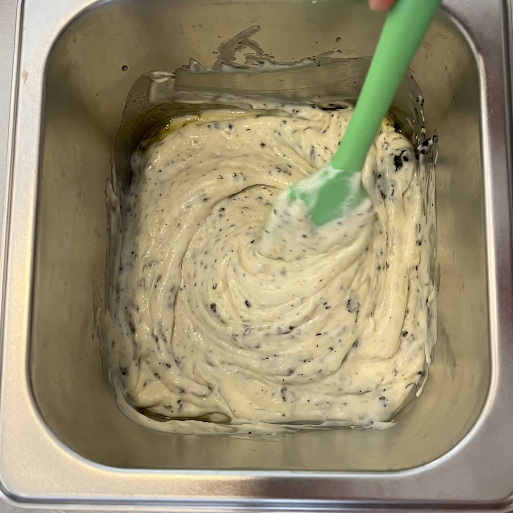 Truffe noire, mayonnaise et huile dolive mélangées dans un récipient en métal.