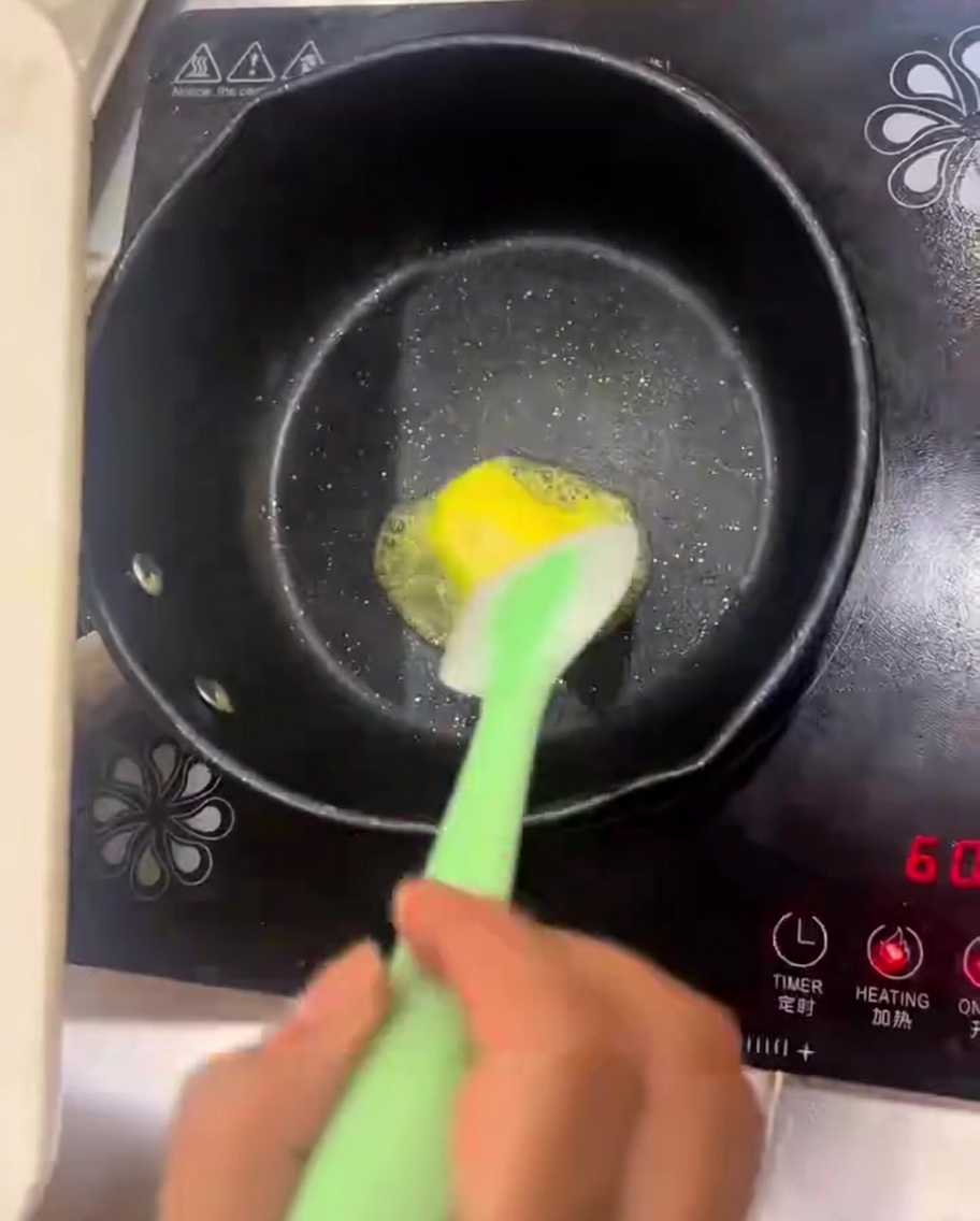 Beurre fondant dans une poêle avec des oignons et des champignons en cours de cuisson.