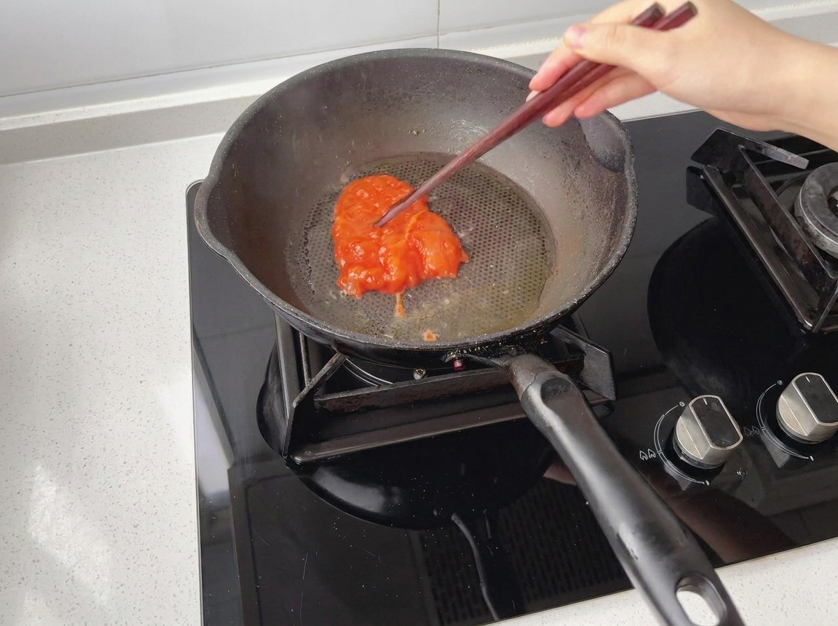 Morceaux de poulet mariné placés dans une poêle préchauffée et huilée.